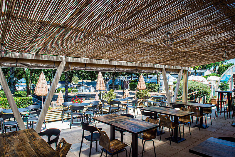 Het terras van de bar van het Parc du Charouzech, camping in Aveyron